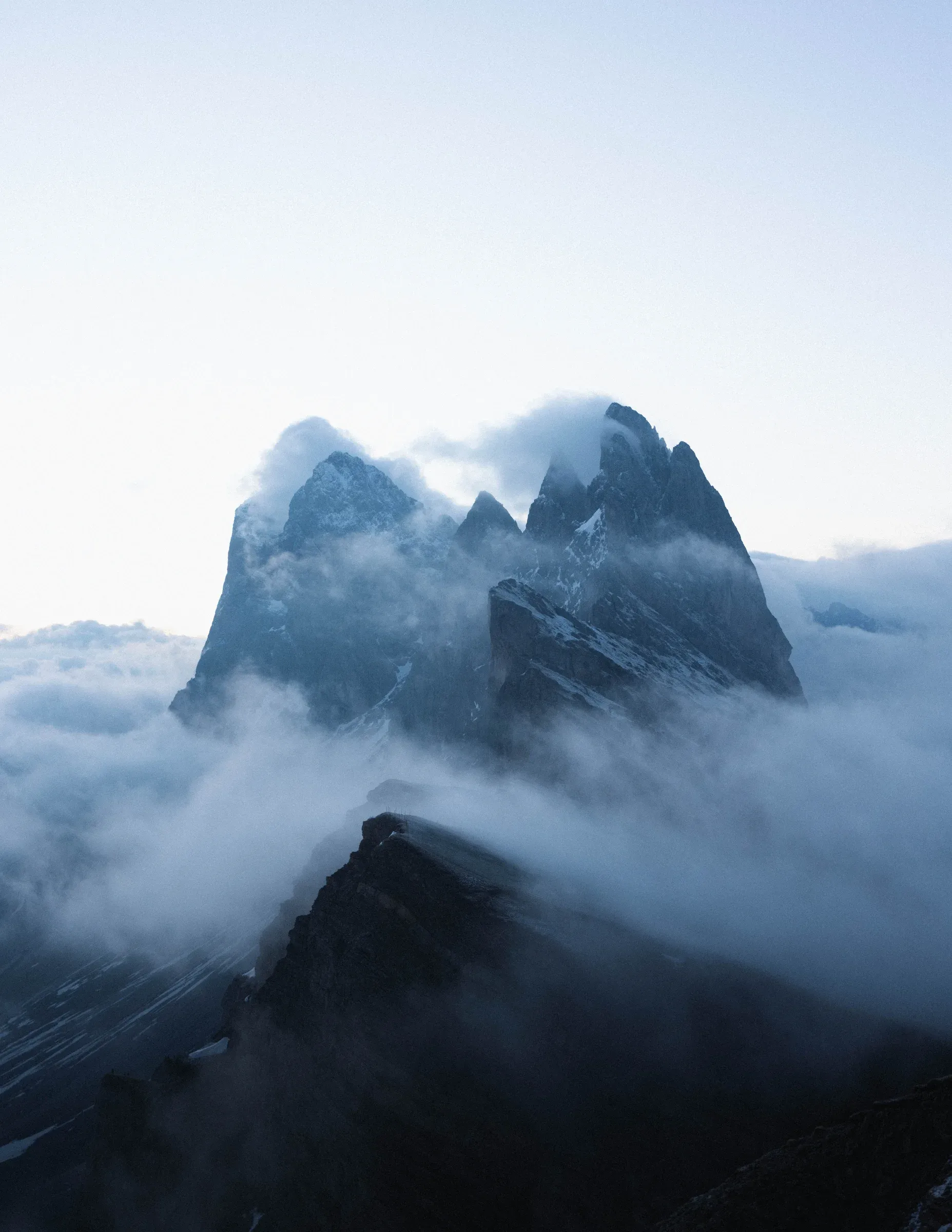 Blue mountain peaks rising from a bank of mist