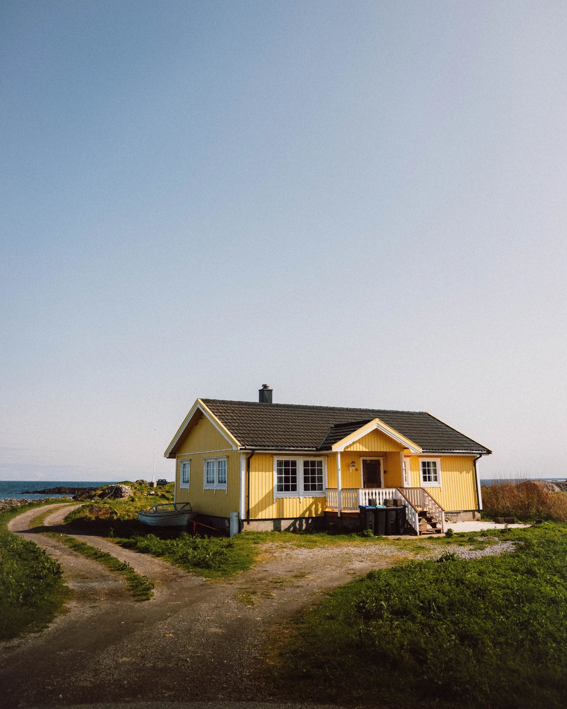 A yellow wooden house beside the water